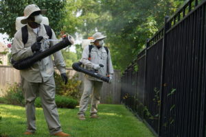Mosquito Joe technicians in protective gear applying barrier treatments 